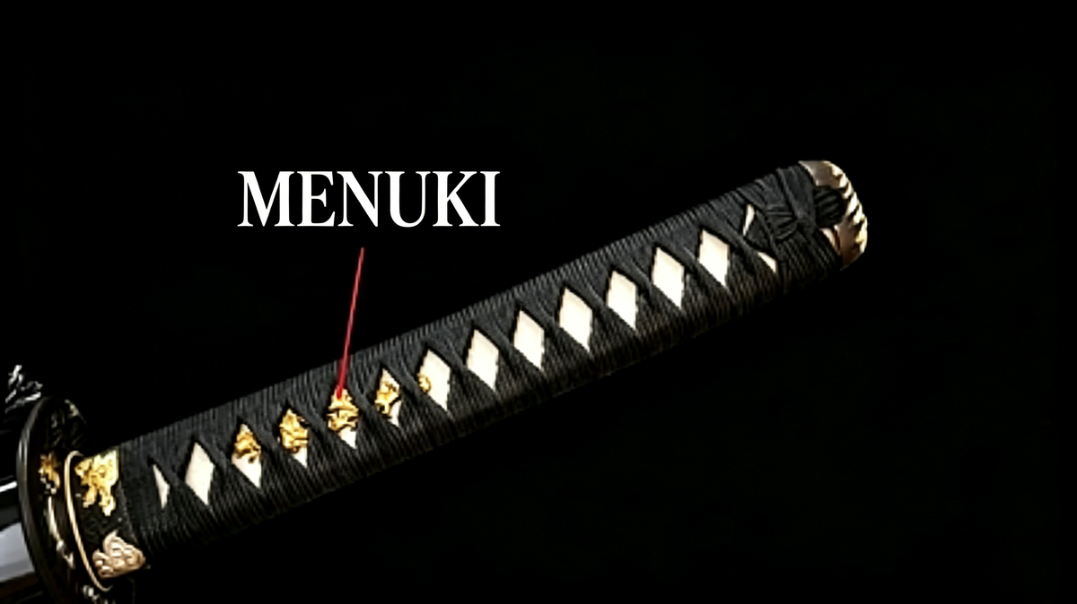 Dark‑background studio close‑up of katana tsuka handle, white annotation arrow pointing to golden menuki ornaments exposed through tsuka‑ito diamond gaps