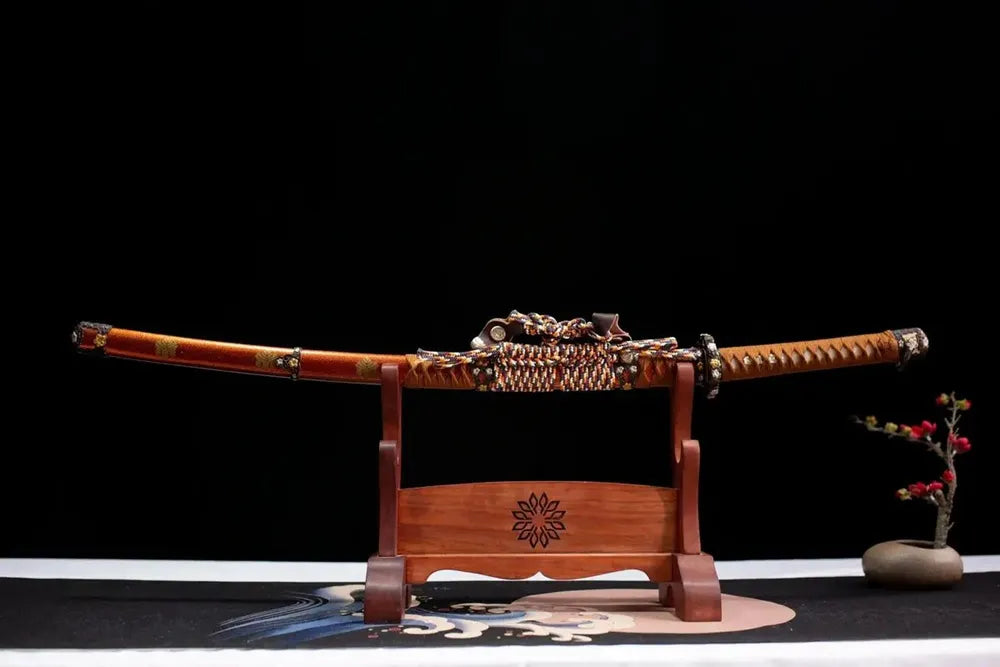 Horizontal laid closed orange glitter mon‑emblem Hideyoshi tachi scabbard flat table‑top front display