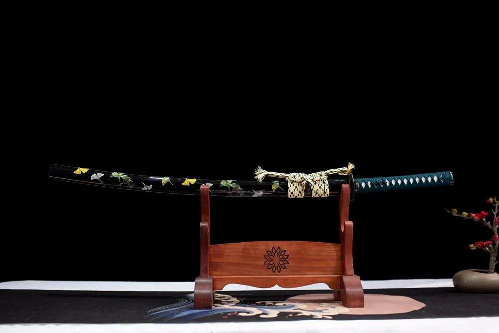 Horizontal laid closed ivory ginkgo‑print scabbard flat table‑top front display