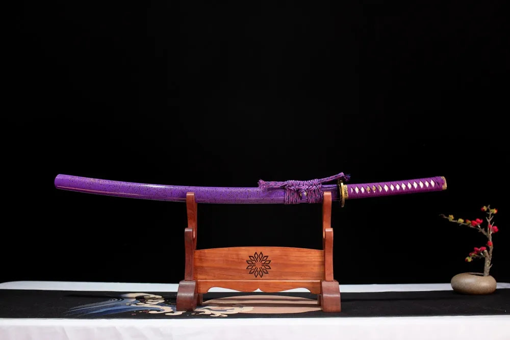 Horizontal laid closed violet‑purple shattered‑gold‑flake Gold‑Band‑Katana scabbard flat table‑top front display