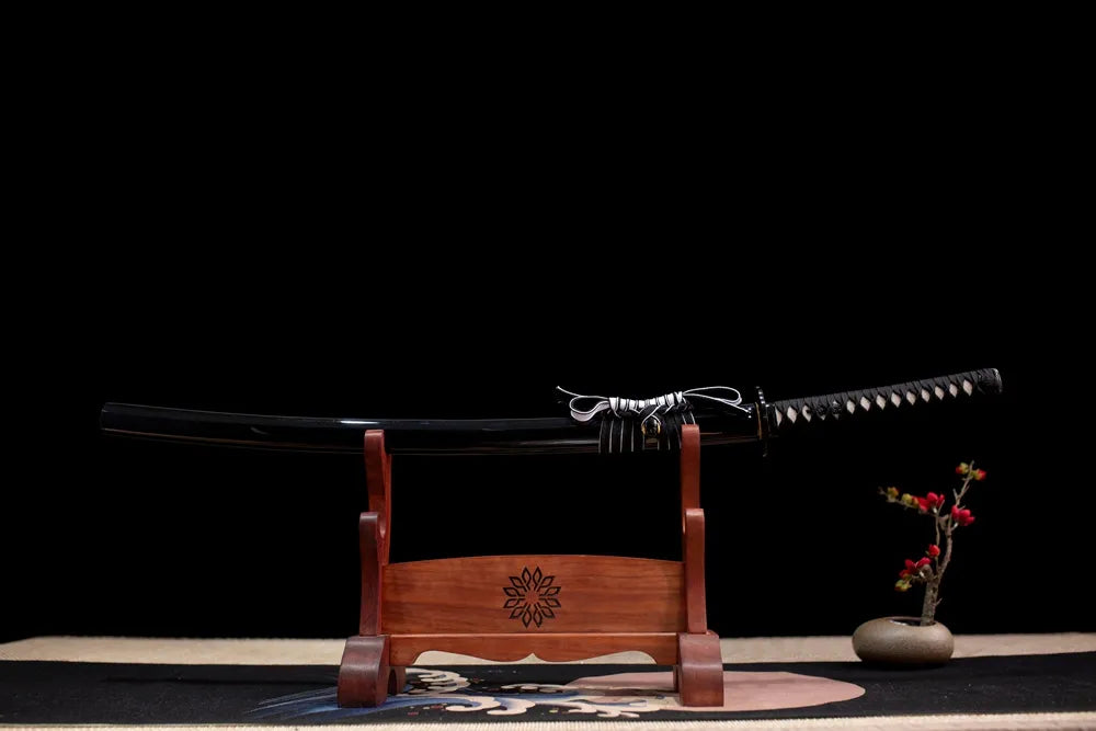 Horizontal laid closed matte‑black scarlet‑spider Black‑Widow‑Katana scabbard flat table‑top front display