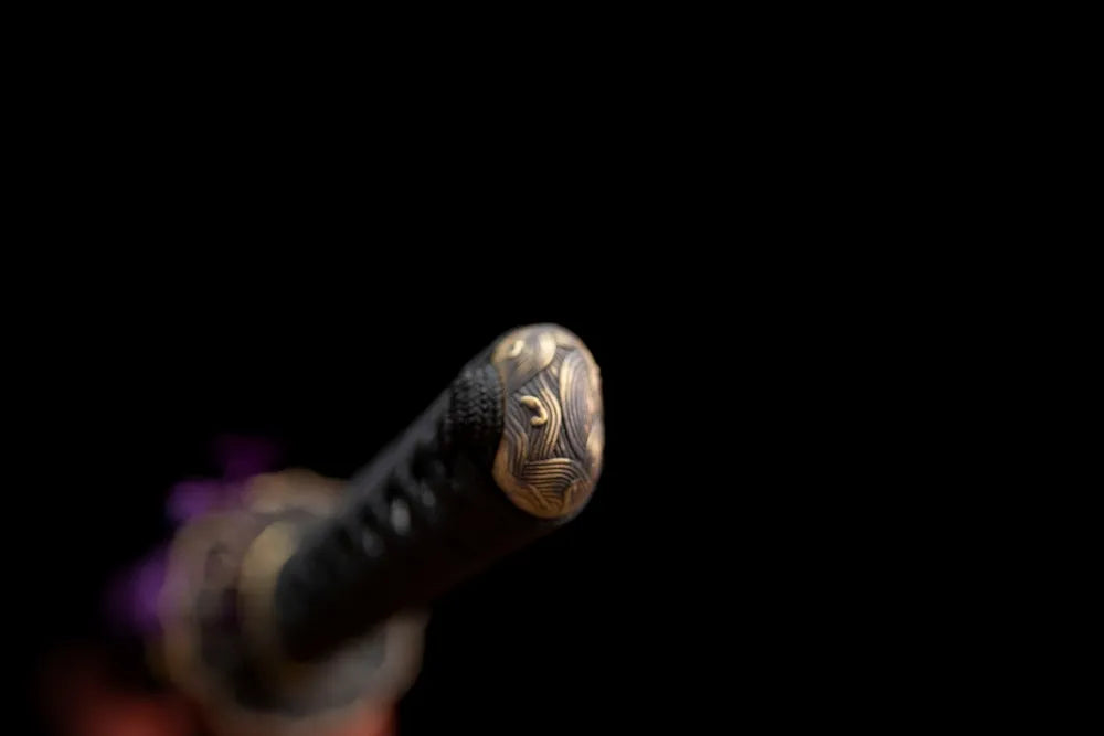 Wave‑snake‑engraved antique‑bronze pommel‑cap detail shot