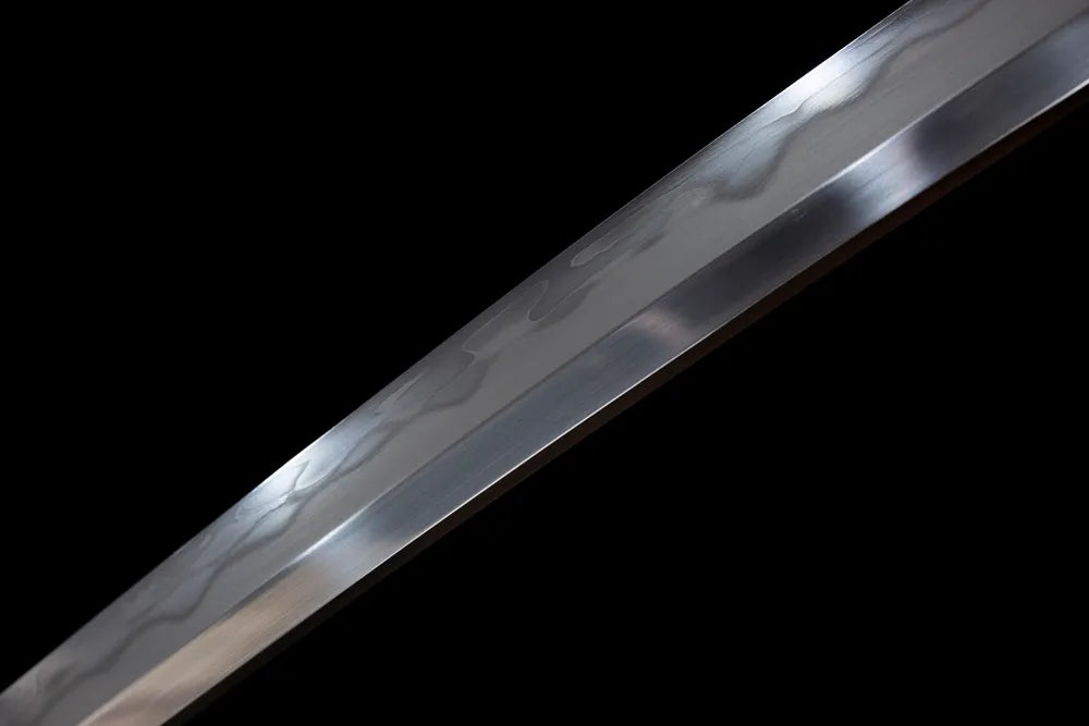 Mid‑section gunomu wavy‑pattern hamon composite‑steel wakizashi blade surface close‑up shot