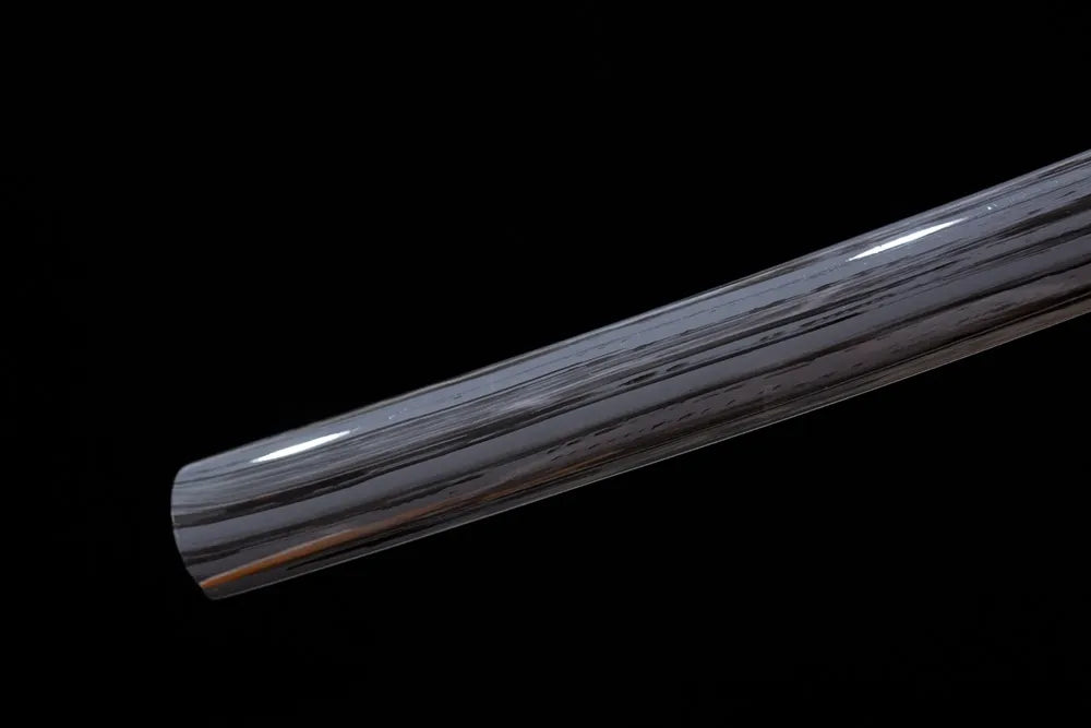 Bottom charcoal‑black saya brass kojiri end‑cap close‑up