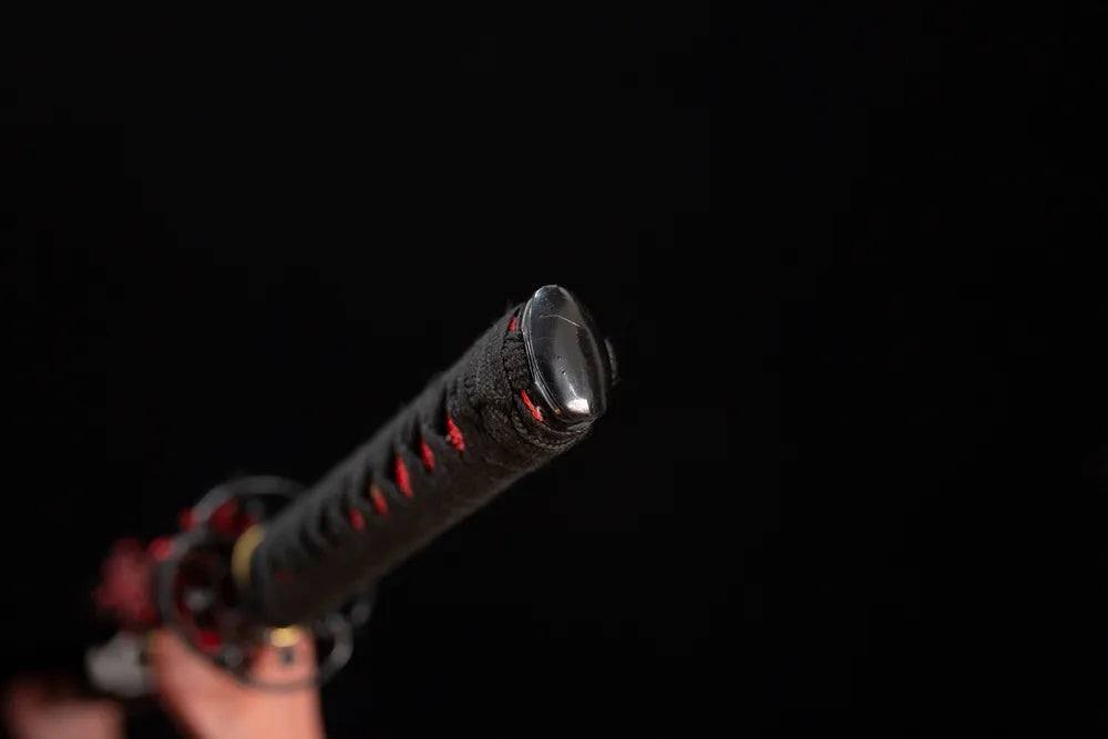 Smooth polished solid‑black wakizashi pommel‑cap detail shot