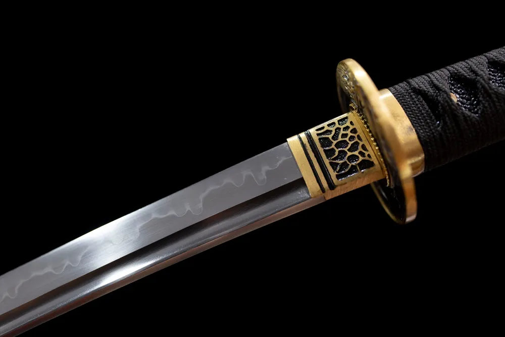 Upper T10 clay‑tempered wakizashi blade brass habaki and visible hamon line macro close‑up
