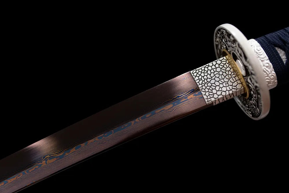 Upper damascus oil‑quenched folded‑grain steel blade copper habaki macro close‑up