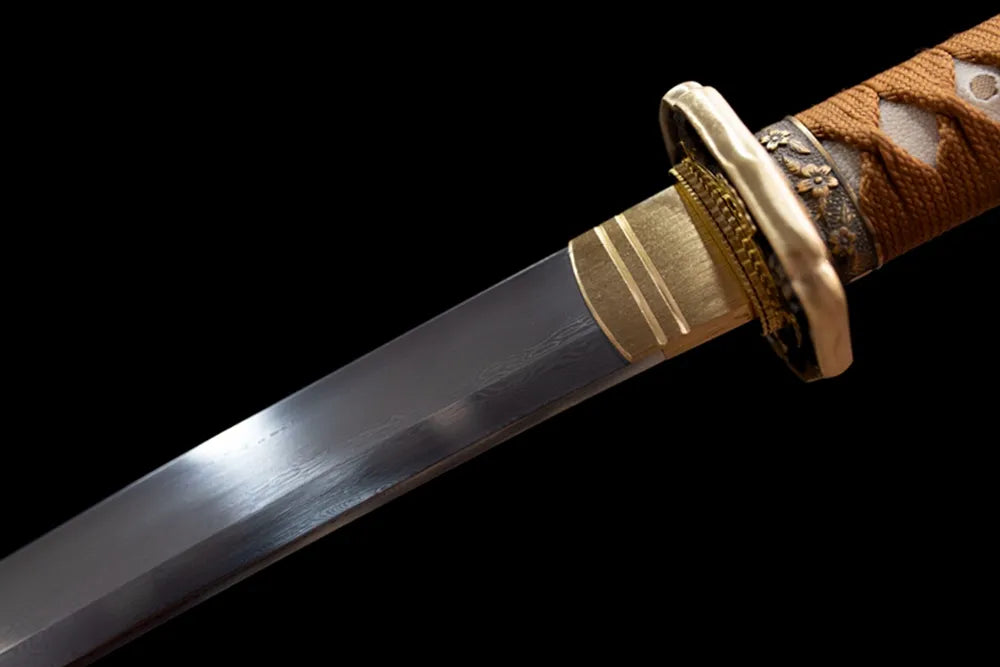 Upper damascus folded oil‑quenched steel blade brass habaki macro close‑up