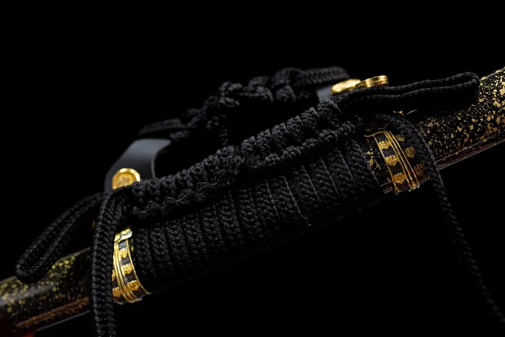 Thick black heavy braided tachi‑no‑sageo cord gilded‑alloy fitting macro close‑up