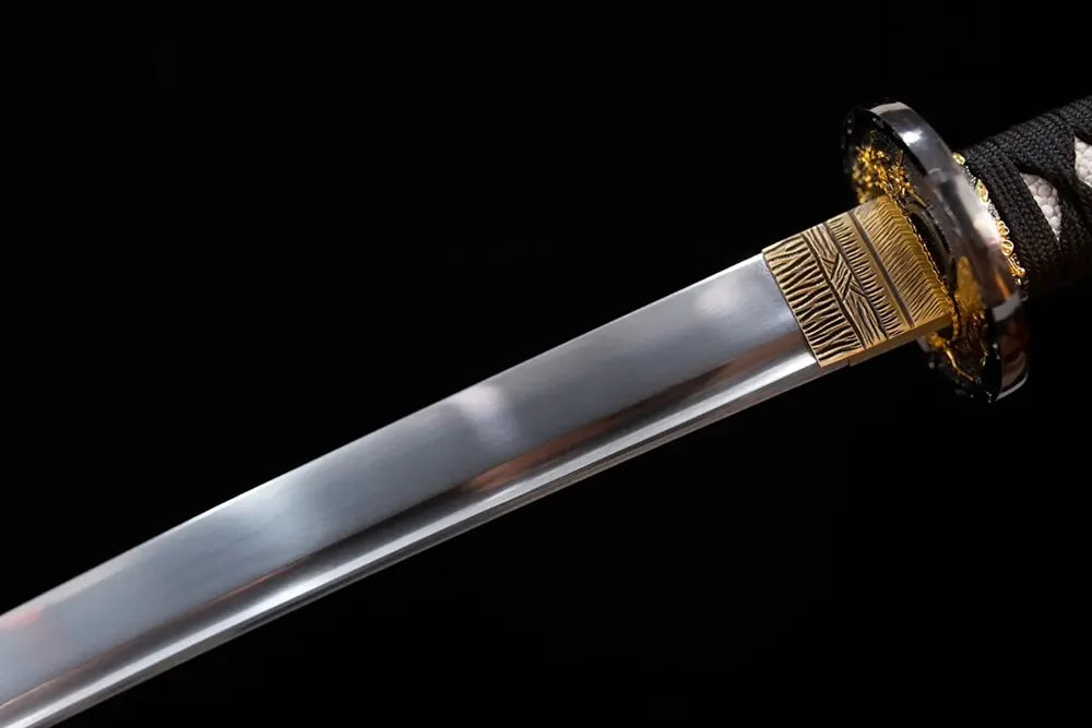 Upper 1060 oil‑quenched katana blade brass habaki taganeha hand‑polished plain blade surface macro close‑up