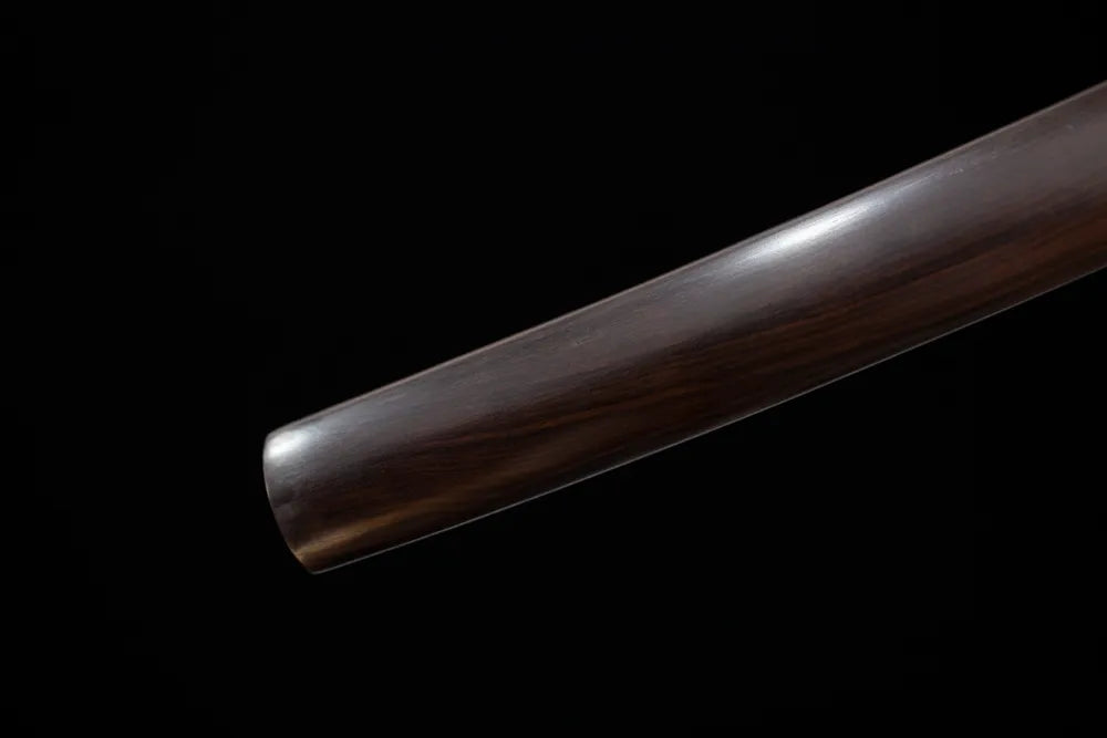 Bottom high‑gloss solid‑black saya textured vintage‑brass kojiri end‑cap close‑up