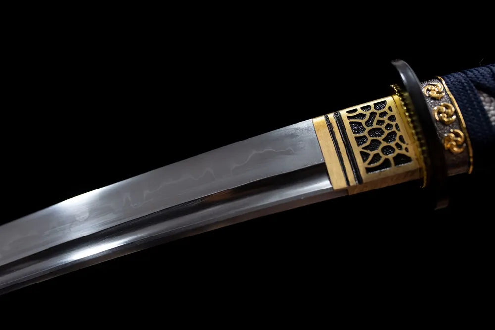 Upper T10 clay‑tempered wakizashi blade brass habaki clean suguha straight hamon temper‑line macro close‑up