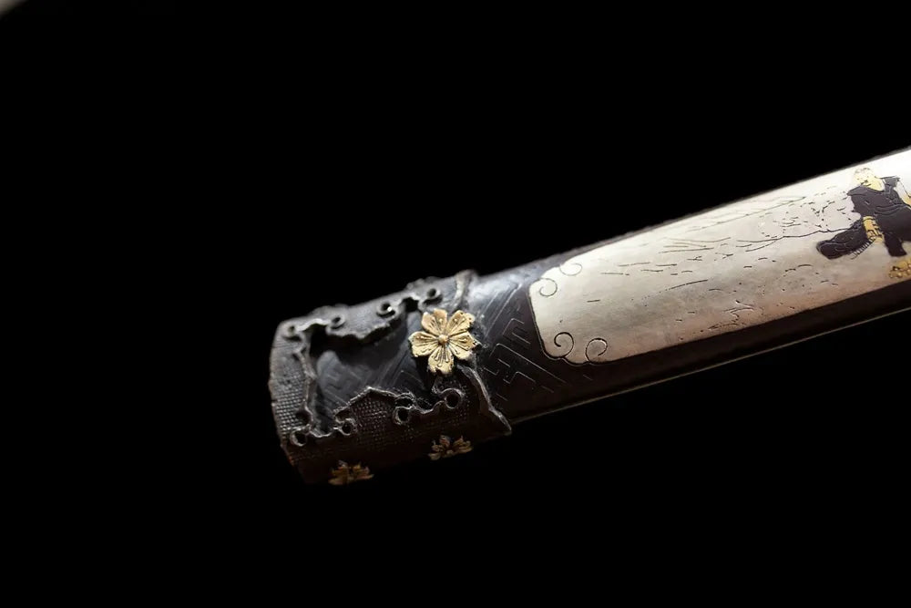 Bottom gold‑leaf maki‑e saya brass‑alloy kojiri end‑cap close‑up