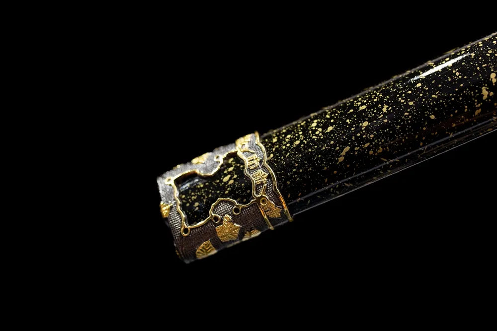Bottom black‑gold speckled saya gilded‑alloy kojiri end‑cap close‑up