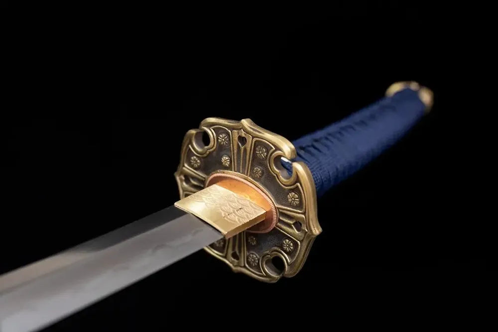 Front open‑work four‑leaf‑clover‑family‑crest‑relief vintage‑brass tachi hand‑guard close‑up