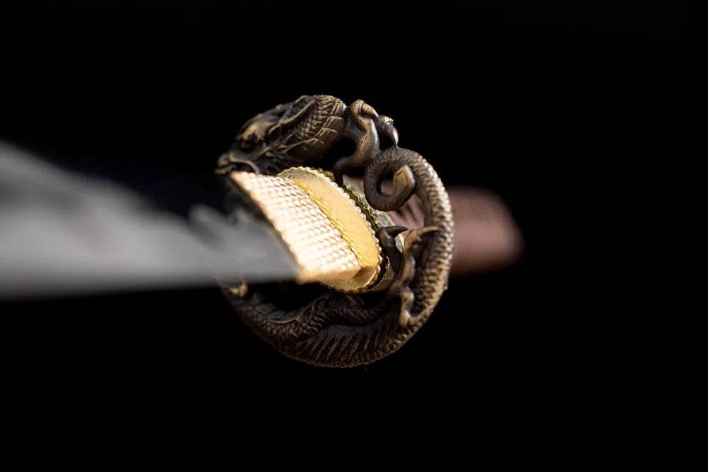 Front open‑work coiled‑dragon‑relief antique‑brass wakizashi hand‑guard close‑up