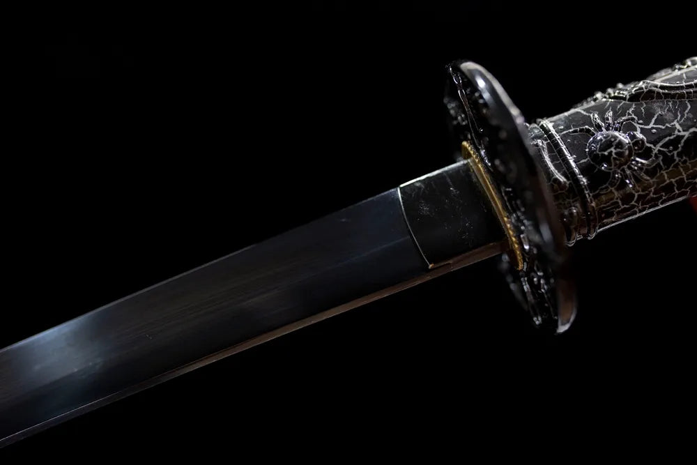Upper blued high‑carbon steel blade alloy habaki macro close‑up