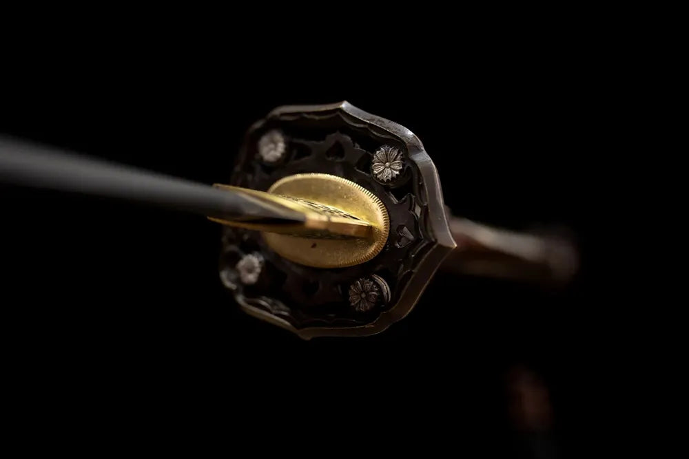 Front mansion‑crest relief‑embossed brass‑alloy tachi hand‑guard close‑up