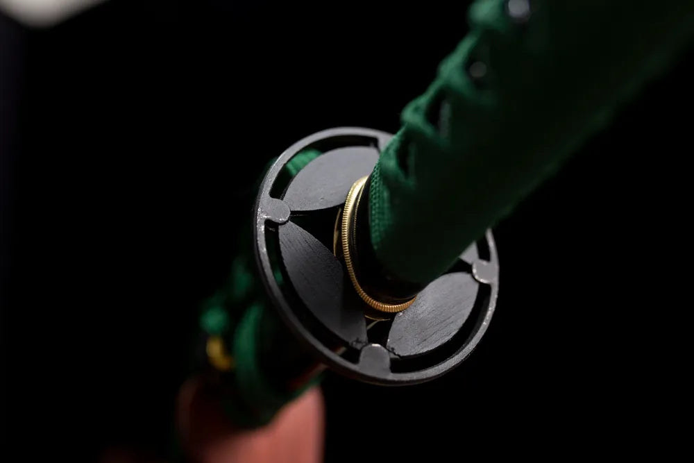 Front open‑work green‑python‑relief aged‑alloy katana hand‑guard close‑up