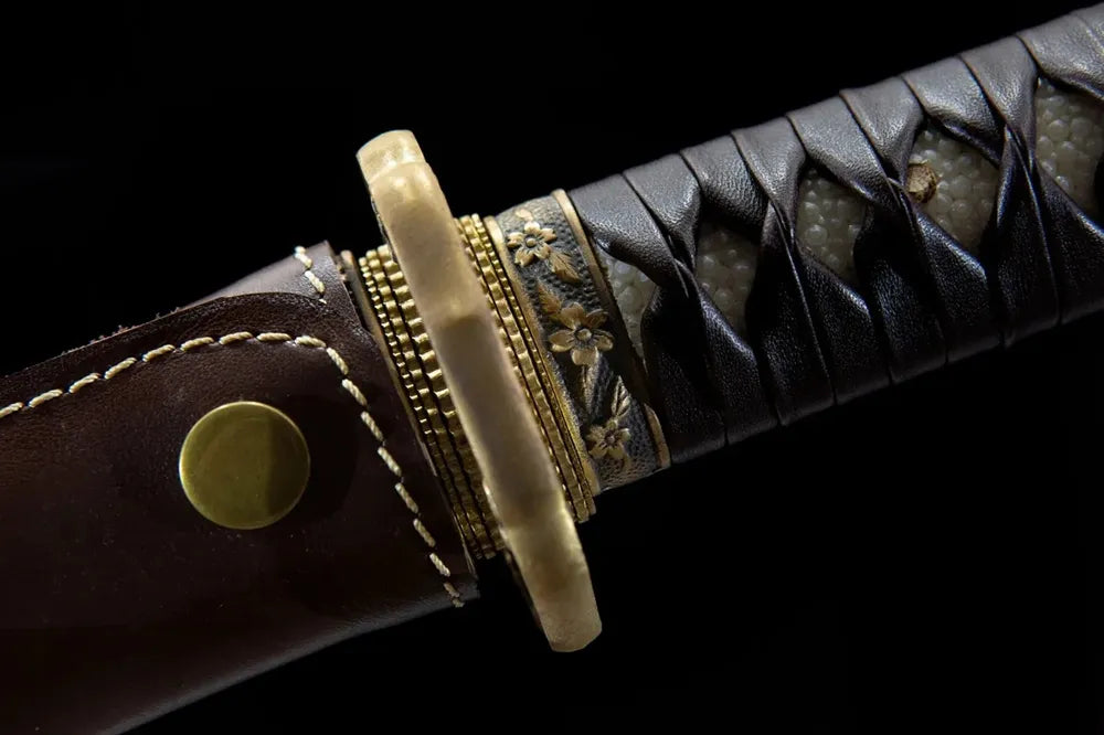 Floral brass fuchi close-up