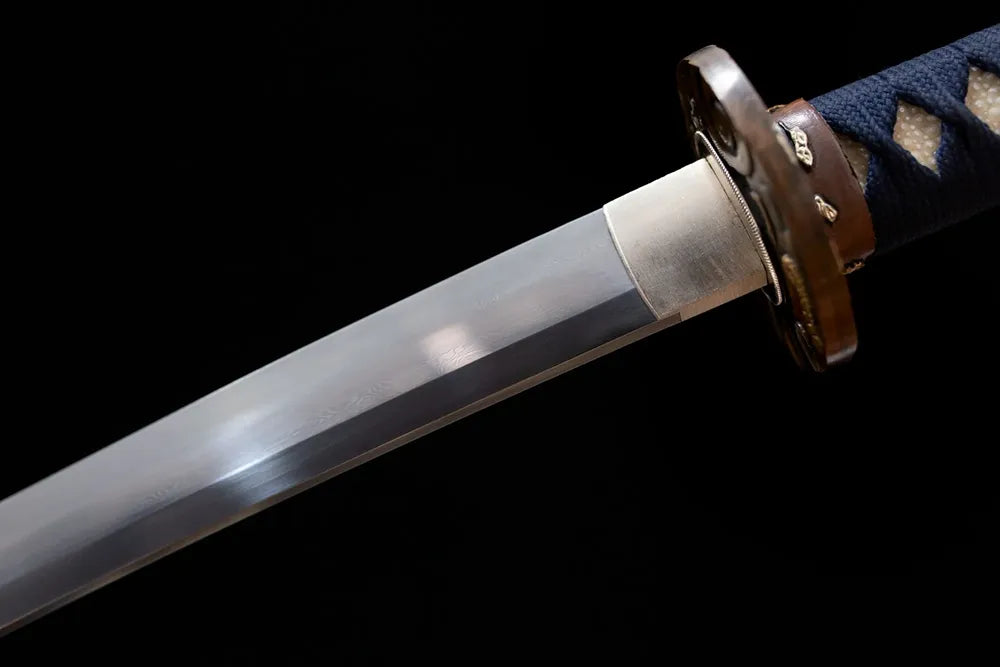 Upper T10 clay‑tempered katana blade brass habaki midare‑badamashi chaotic‑varied hamon temper‑line macro close‑up