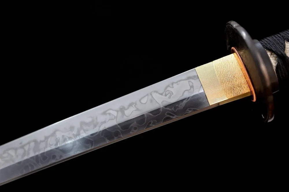 Upper T10 clay‑tempered katana blade brass habaki suguha‑midare ink‑diffusion flowing hamon temper‑line macro close‑up