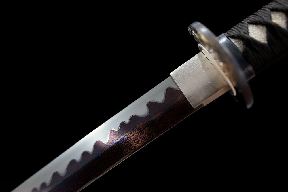 Upper damascus folded oil‑quenched steel blade copper habaki blade‑base macro close‑up