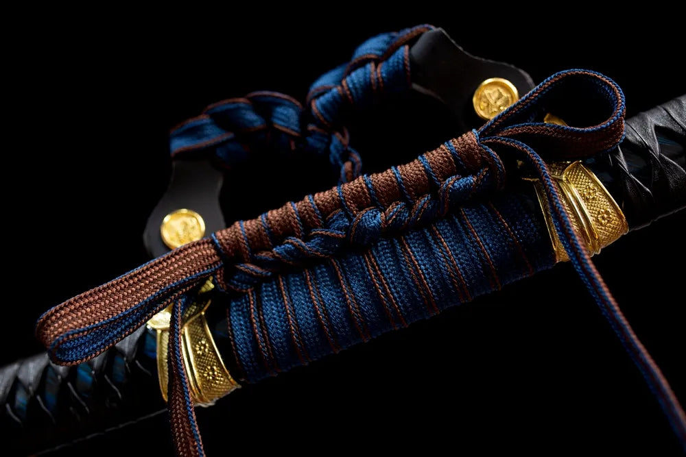Thick blue‑brown mixed‑braided tachi‑no‑sageo cord gilded‑brass fitting macro close‑up