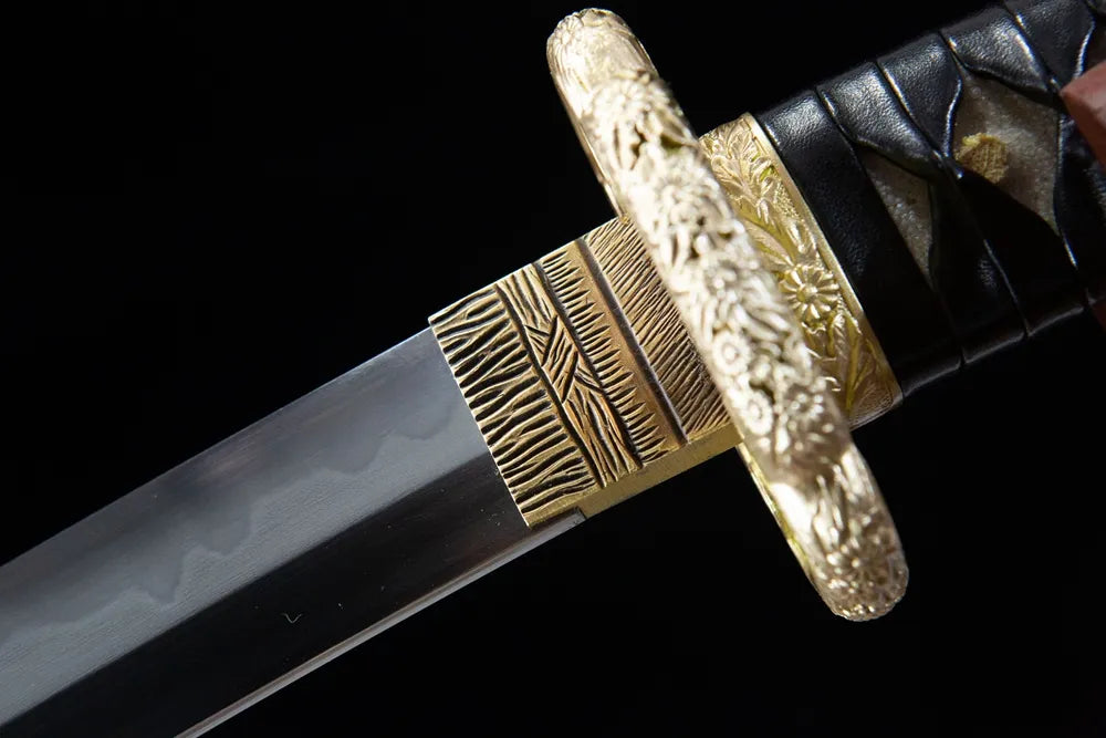 Upper long blade closeup smooth mirror T10 steel near hollow gilded brass habaki