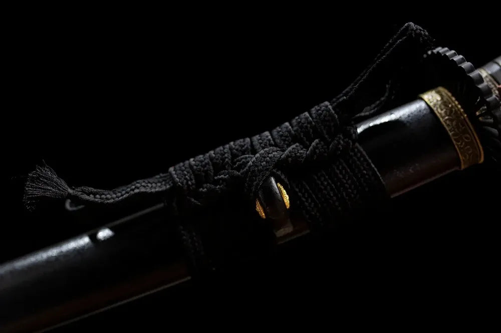 Thick charcoal‑black heavy‑braided tachi‑no‑sageo cord matte‑dark alloy fitting macro close‑up