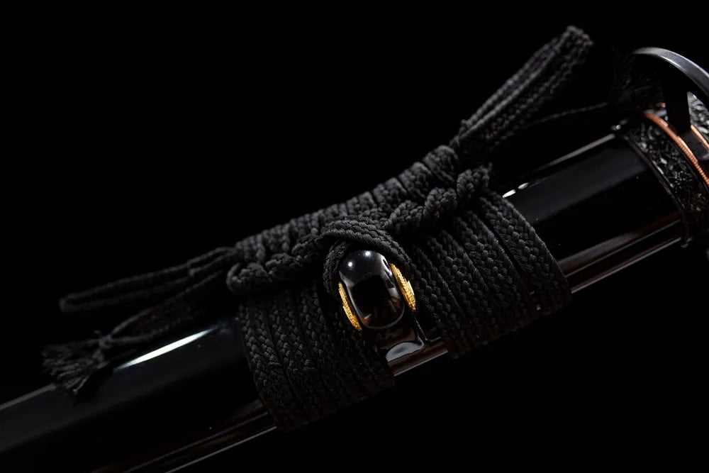 Thick black braided sage cord golden metal fitting macro shot