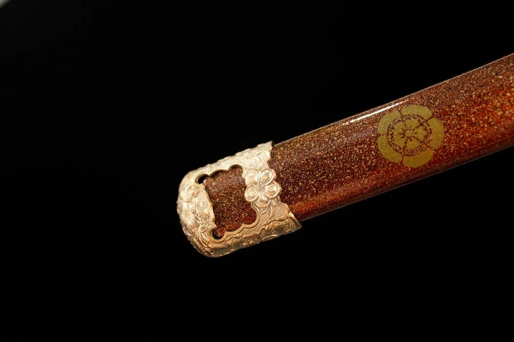 Bottom orange‑red saya gilded‑alloy kojiri end‑cap close‑up