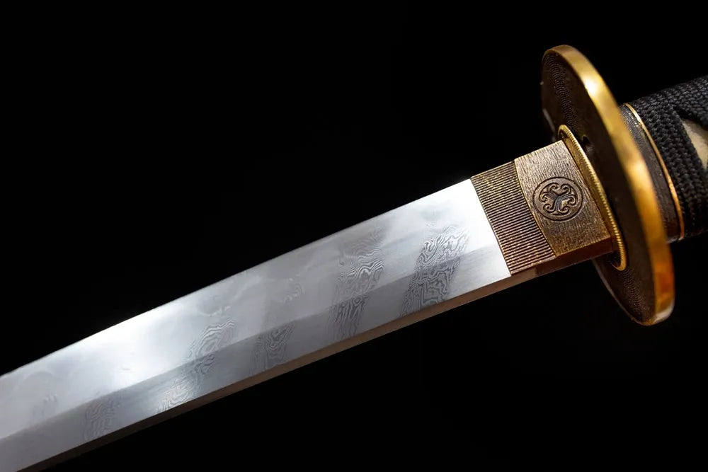 Upper hand‑forged damascus‑steel katana blade brass habaki natural wave‑pattern flowing hamon grain macro close‑up