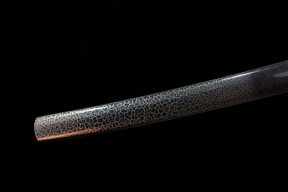 Bottom charcoal‑black saya matte‑dark‑aged‑copper kojiri end‑cap close‑up
