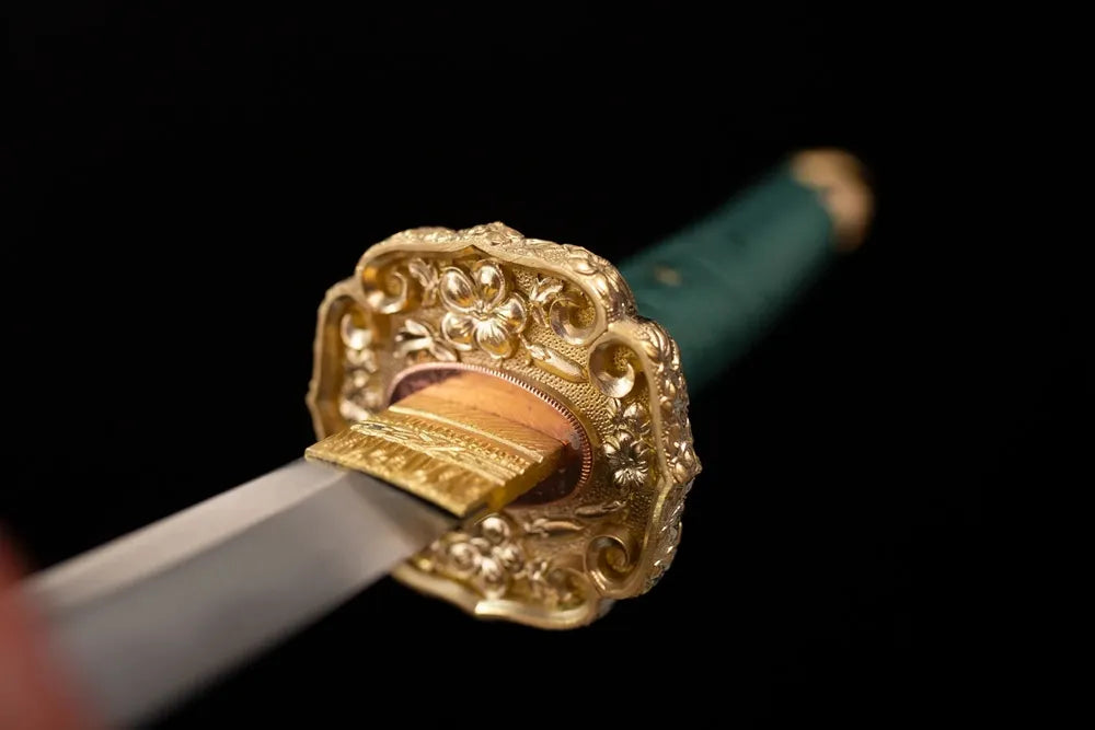 Front open‑work clan‑crest‑kamon‑cherry‑chrysanthemum‑relief gilded‑alloy tachi hand‑guard close‑up
