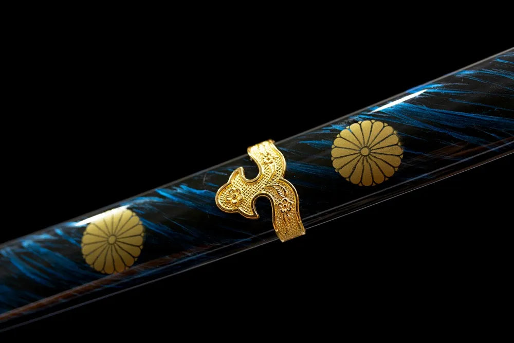 Mid‑section deep‑blue lacquer hardwood tachi saya gilded chrysanthemum‑mon emblem texture close‑up