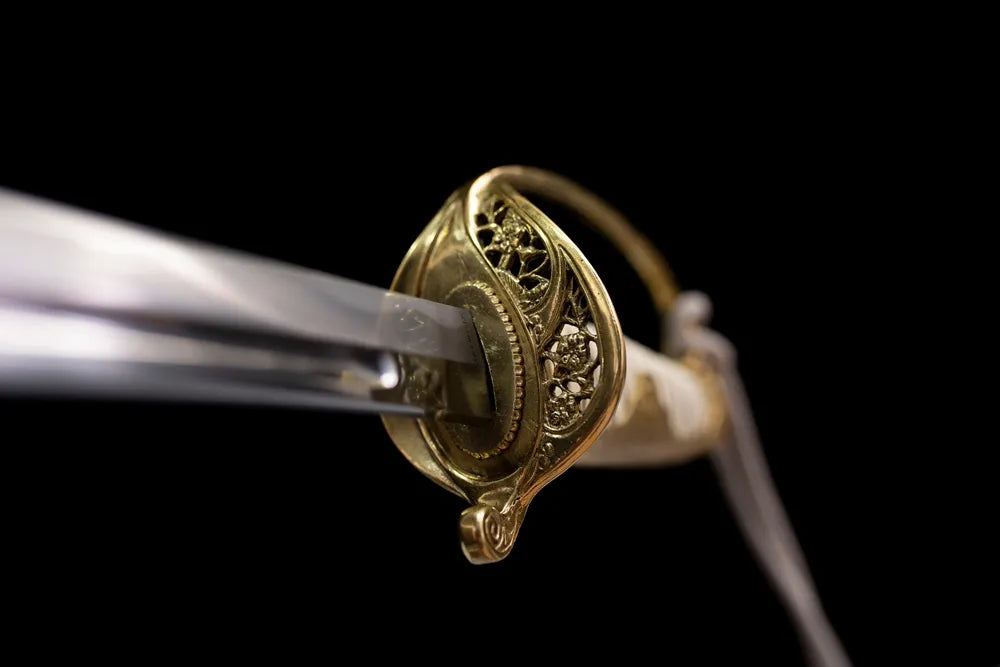 Front ornate open‑work floral‑engraved brass D‑shaped cavalry‑saber guard close‑up