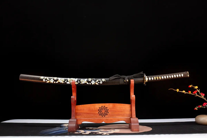 This jkatana is designed for black enthusiasts, and in order not to make it too dull, we have added romantic flowers to SAYA, making it particularly beautiful in the sun. Accessories such as TSUBA have a golden plum blossom pattern. This is a Katana specially designed for chopping.So I chose 1060 high manganese steel with low price and good performance for the blade.