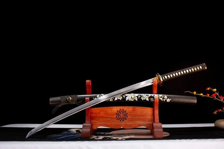 This jkatana is designed for black enthusiasts, and in order not to make it too dull, we have added romantic flowers to SAYA, making it particularly beautiful in the sun. Accessories such as TSUBA have a golden plum blossom pattern. This is a Katana specially designed for chopping.So I chose 1060 high manganese steel with low price and good performance for the blade.