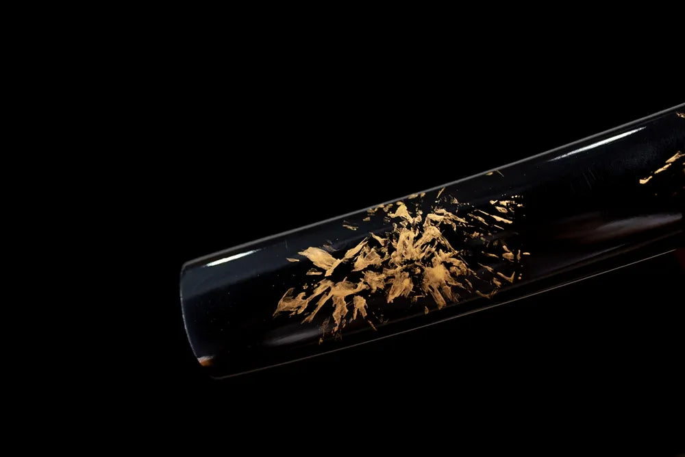 Bottom black gold‑leaf‑flake saya antique‑brass kojiri end‑cap close‑up