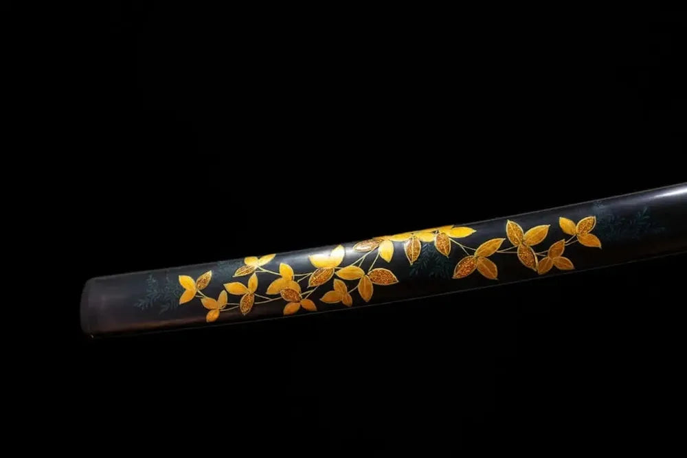 Bottom black‑gold‑gradient saya gilded‑bronze kojiri end‑cap close‑up