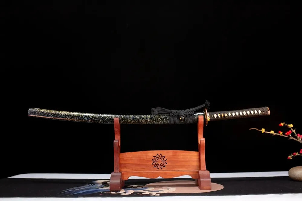 Horizontal laid closed black‑gold‑flake‑speckled Shining‑Katana scabbard flat table‑top front display