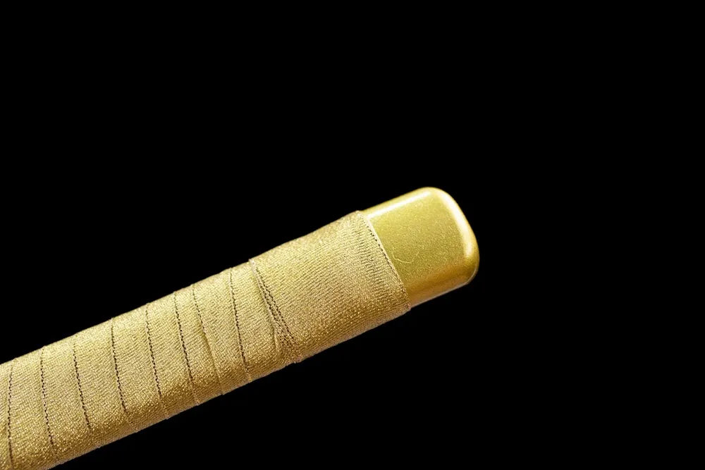 Top golden alloy kashira pommel front close‑up