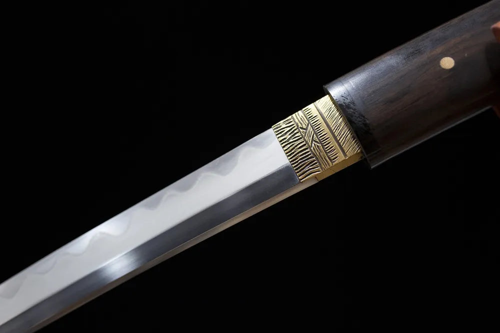 Upper T10 clay‑tempered wakizashi blade brass habaki irregular gunome undulating hamon temper‑line macro close‑up