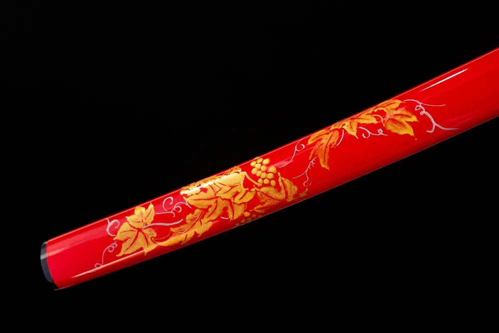Bottom wine‑red saya brass‑gilded kojiri end‑cap close‑up