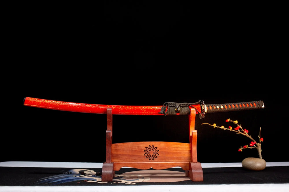 Horizontal laid closed bright‑red golden‑speck scattered‑gold Startled‑Salamander‑Katana scabbard flat table‑top front display