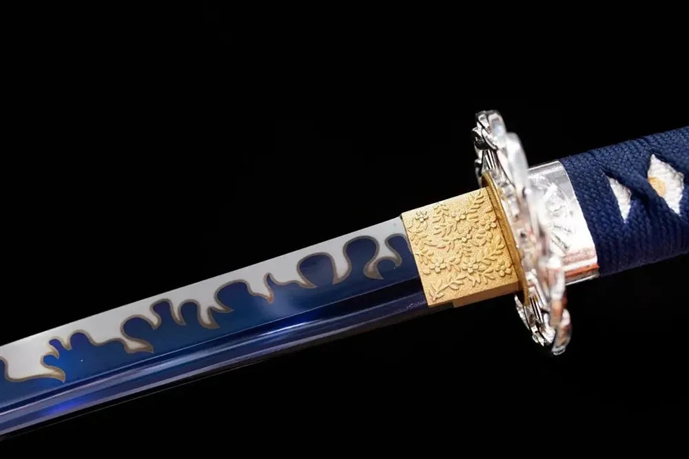 Upper 1060 steel blue‑tinted‑heat‑tinted katana blade brass habaki blue‑tinted‑etched wavy‑ornamental‑edge macro close‑up
