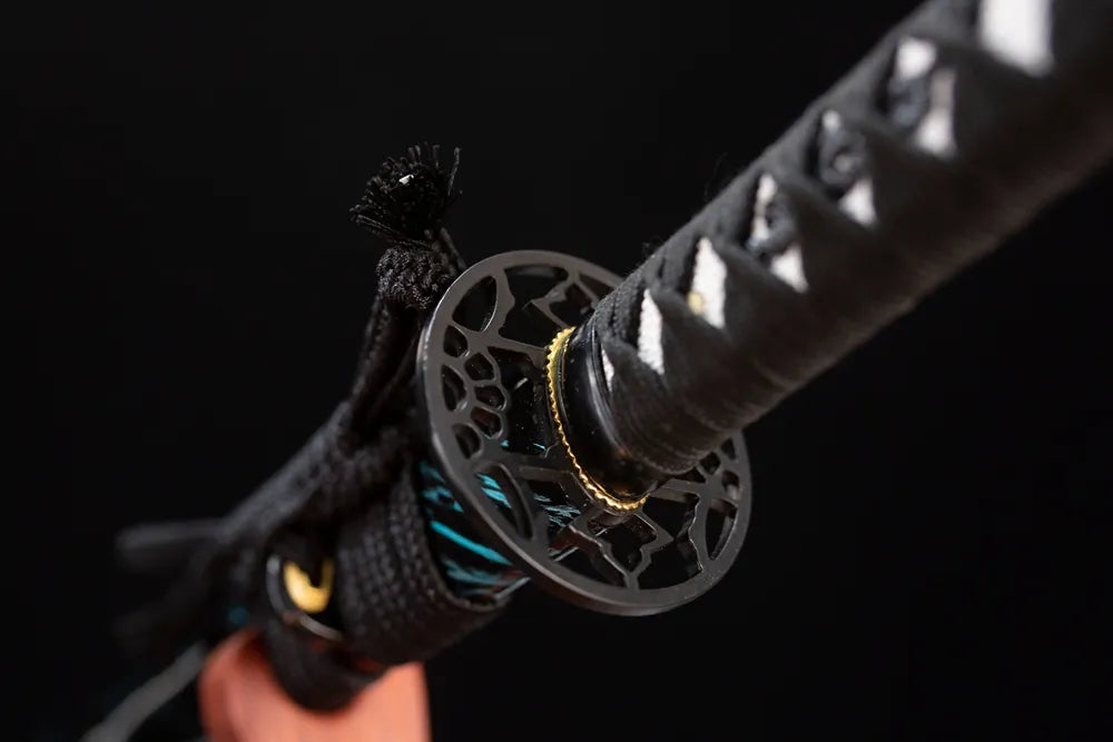 Reverse‑side fiery‑flame‑scroll carving black‑alloy tsuba surface texture close‑up