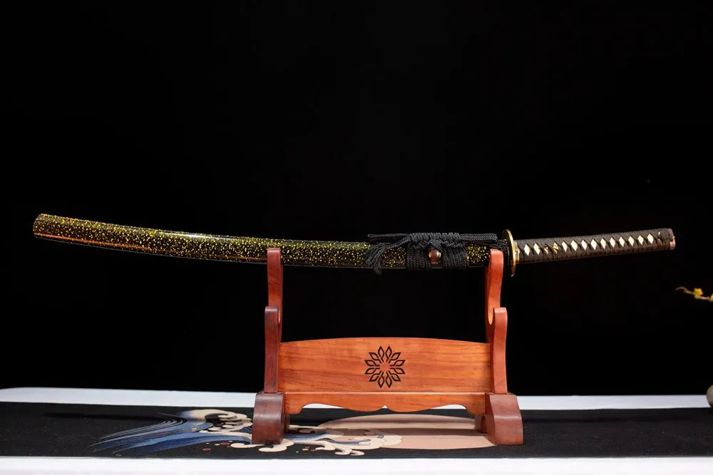 Horizontal laid closed black scattered‑gold‑flakes Paper‑Cranes‑Katana scabbard flat table‑top front display