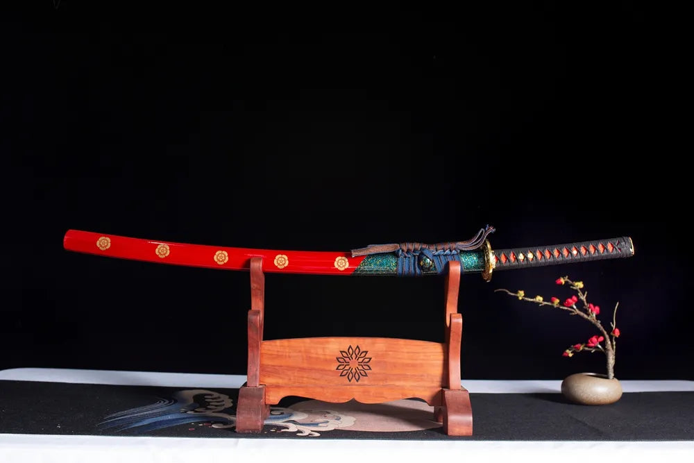 Horizontal laid closed scarlet‑red gilded‑kamon‑hanafuda Qianxi‑Katana scabbard flat table‑top front display